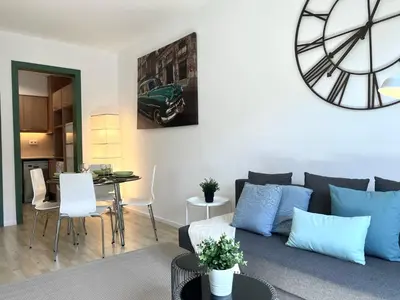a living room with a couch and a clock on the wall at Click&Flat Fontanella in Barcelona