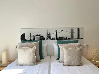 a white bed with a black and white headboard at Click&Flat Fontanella in Barcelona