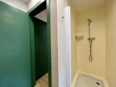 a bathroom with a shower with a green door at Click&Flat Fontanella in Barcelona