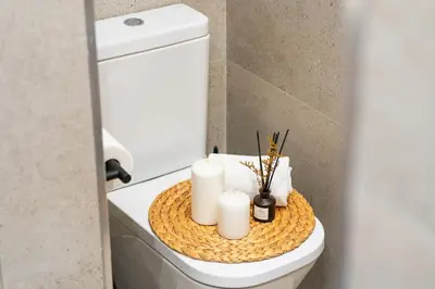 a bathroom with a toilet with candles on it at Lodging Apartments Liceu G1 in Barcelona