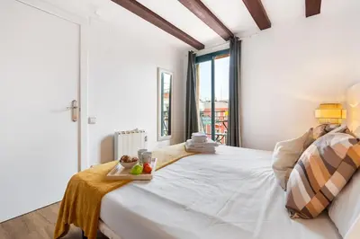 a bedroom with a white bed with a tray of fruit on it at Lodging Apartments Liceu G1 in Barcelona