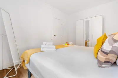 a bedroom with a large white bed with yellow pillows at Lodging Apartments Liceu G2 in Barcelona