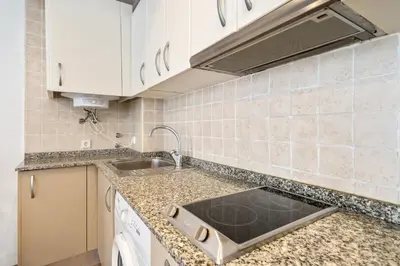 a kitchen with white cabinets and a sink at Lodging Apartments Liceu G2 in Barcelona