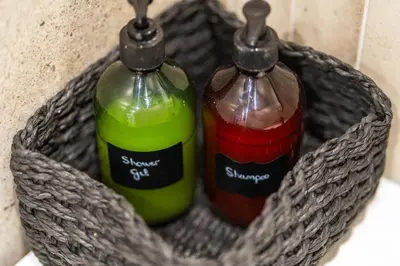 two bottles sitting in a basket on a sink at Lodging Apartments Liceu G2 in Barcelona