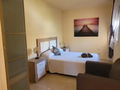a bedroom with a bed and a mirror and a couch at Villa Lluna Sitges 15 minutes drive from Sitges Swimming pool XXL 16 people in Olivella