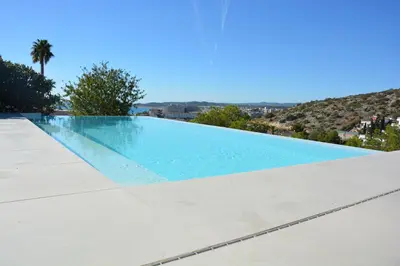 a patio with a table and chairs and a pool at Villa Sitges Colonial. Impressive views of the sea. High design. Renovated. in Sitges