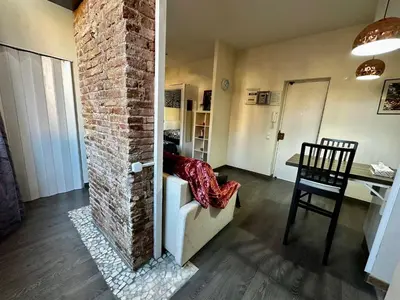 a living room with a couch and a brick wall at Nice apartment close to park Guell1 in Barcelona