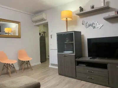 a living room with a tv and a entertainment center at COMFORTABLE APARTMENT CLOSE TO BUNKERS DEL CARMEL! in Barcelona