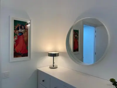 a room with a mirror and a lamp on a dresser at Family Apartment in Vilanova i la Geltrú