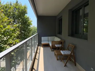 a porch with chairs and a couch on a balcony at Family Apartment in Vilanova i la Geltrú
