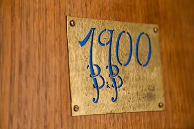 a sign on a wooden wall with the word krone at 1900 B&B Terrassa in Terrassa