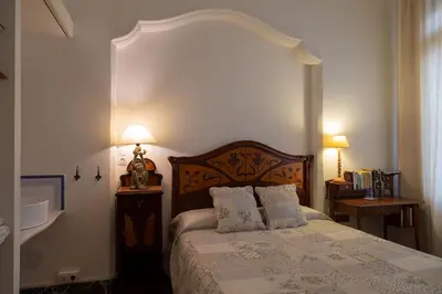 a bedroom with a bed with two night stands and two lamps at 1900 B&B Terrassa in Terrassa