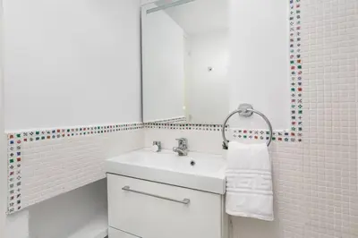 a white bathroom with a sink and a mirror at Estudio Bogatell Beach Se admiten mascotas AC in Barcelona