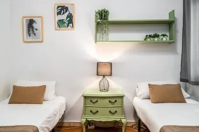 a room with two beds and a table with a lamp at Arc de Triomf Base 4BR for 5 Lift in Barcelona