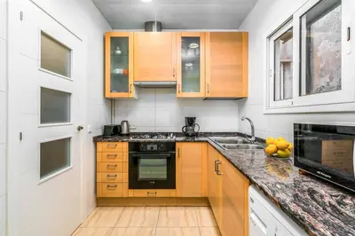a kitchen with wooden cabinets and a counter top at Arc de Triomf Base 4BR for 5 Lift in Barcelona