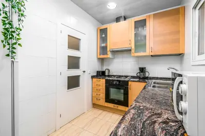 a kitchen with wooden cabinets and a stove at Arc de Triomf Base 4BR for 5 Lift in Barcelona