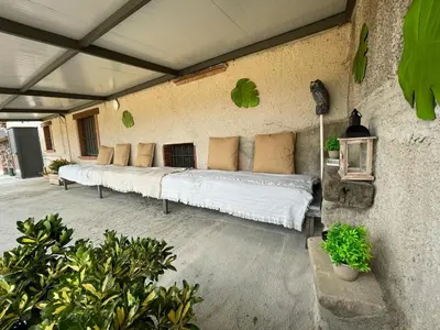 a row of white beds sitting on a patio at Molí den burch in Santa Eulalia de Ronsaná