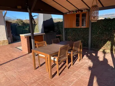 a wooden table and chairs on a patio at Molí den burch in Santa Eulalia de Ronsaná