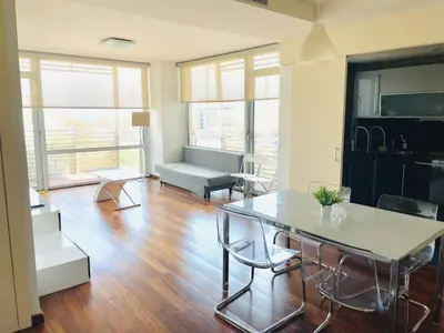 a living room with a table and a couch at Forum de Barcelona Sea View Apartment with Garage Parking in Sant Adria de Besos