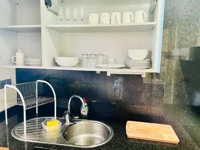 a kitchen with a sink and white dishes on shelves at Forum de Barcelona Sea View Apartment with Garage Parking in Sant Adria de Besos