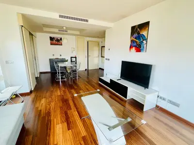 a living room with a television and a table at Forum de Barcelona Sea View Apartment with Garage Parking in Sant Adria de Besos