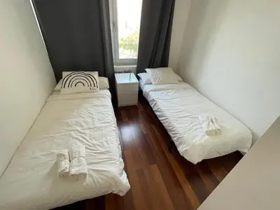two beds in a small room with a window at Forum de Barcelona Sea View Apartment with Garage Parking in Sant Adria de Besos