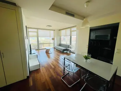 a living room with a table and a couch at Forum de Barcelona Sea View Apartment with Garage Parking in Sant Adria de Besos