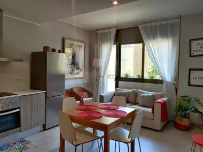 a kitchen and living room with a table and a couch at Fira Plaza España apartment in Barcelona