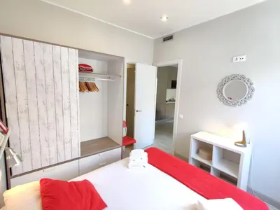 a bedroom with a red bed and a mirror at Fira Plaza España apartment in Barcelona