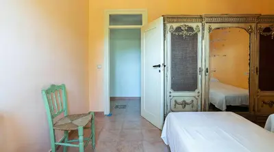 a bedroom with a bed and a chair in a room at Casa Can Roura in Vilassar de Dalt