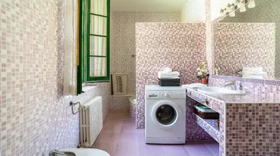 a bathroom with a washing machine and a sink at Casa Can Roura in Vilassar de Dalt