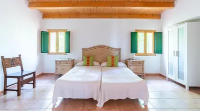 a bedroom with a large bed and a chair at Casa Can Roura in Vilassar de Dalt
