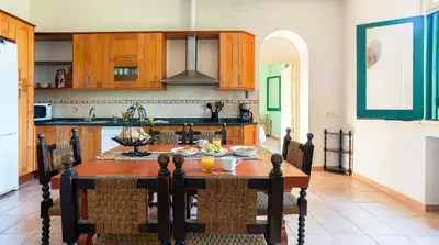 a kitchen with a wooden table in a room at Casa Can Roura in Vilassar de Dalt