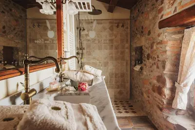 a bathroom with a sink and a brick wall at Masia Can Viver - Olive oil tourism B&B in Bigues i Riells