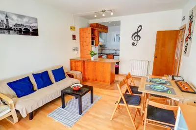 a living room with a couch and a table at Hermione Apartment by Hello Homes Sitges in Sitges