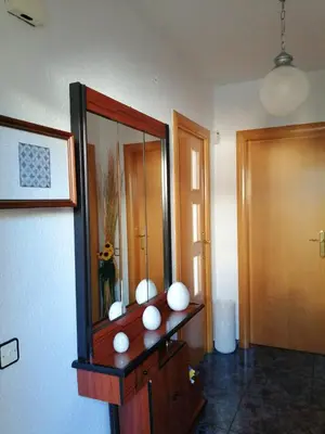 a room with a mirror and a wooden cabinet at Apartamento Bella Carmen : para 6 personas in Cunit