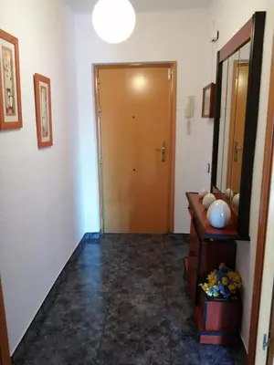 a hallway with a door and a table and a mirror at Apartamento Bella Carmen : para 6 personas in Cunit