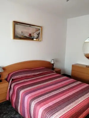 a bedroom with a bed with a striped bedspread at Apartamento Bella Carmen : para 6 personas in Cunit