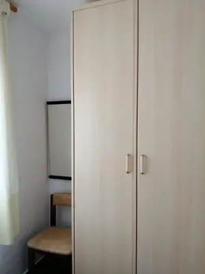 a white cabinet in a room with a chair at Apartamento Bella Carmen : para 6 personas in Cunit