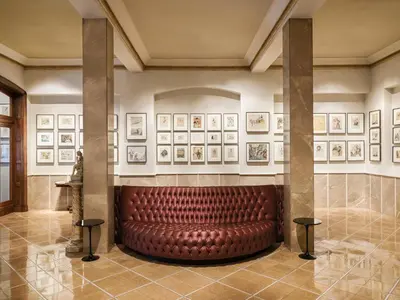 a leather seat in a room with pictures on the wall at Hotel Astoria in Barcelona