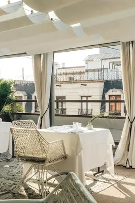 a restaurant with white tables and chairs on a balcony at Claris Hotel & Spa GL, a Small Luxury Hotel of the World in Barcelona