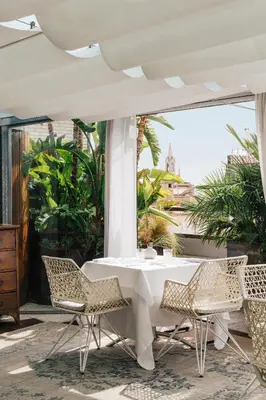a white table and chairs on a patio at Claris Hotel & Spa GL, a Small Luxury Hotel of the World in Barcelona