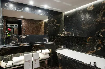 a bathroom with a large mirror and a bath tub at Claris Hotel & Spa GL, a Small Luxury Hotel of the World in Barcelona