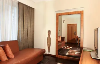 a living room with a couch and a mirror at Hotel Gran Derby Suites, a Small Luxury Hotel of the World in Barcelona