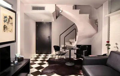 a living room with a couch and a mirror at Hotel Gran Derby Suites, a Small Luxury Hotel of the World in Barcelona