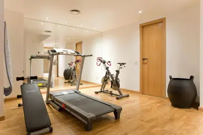 a gym with two exercise bikes and a treadmill at Hotel Gran Derby Suites, a Small Luxury Hotel of the World in Barcelona