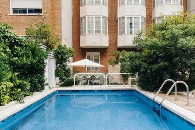 a swimming pool in front of a building at Hotel Derby in Barcelona