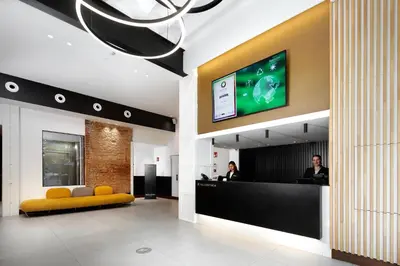 a lobby with a reception desk and a tv at HCC Taber in Barcelona