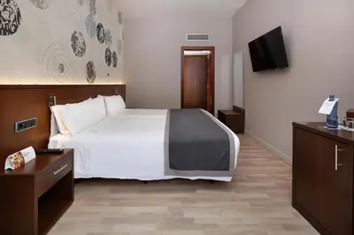 a hotel room with a bed and a flat screen tv at HCC Taber in Barcelona