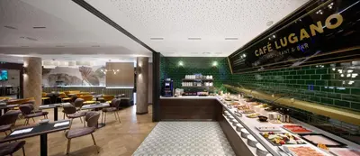 a restaurant with green tiled walls and a buffet at HCC St. Moritz in Barcelona